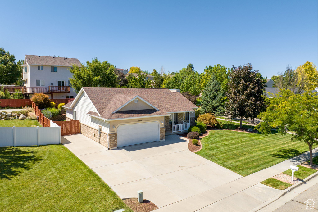 View of front of property featuring a garage and a front lawn