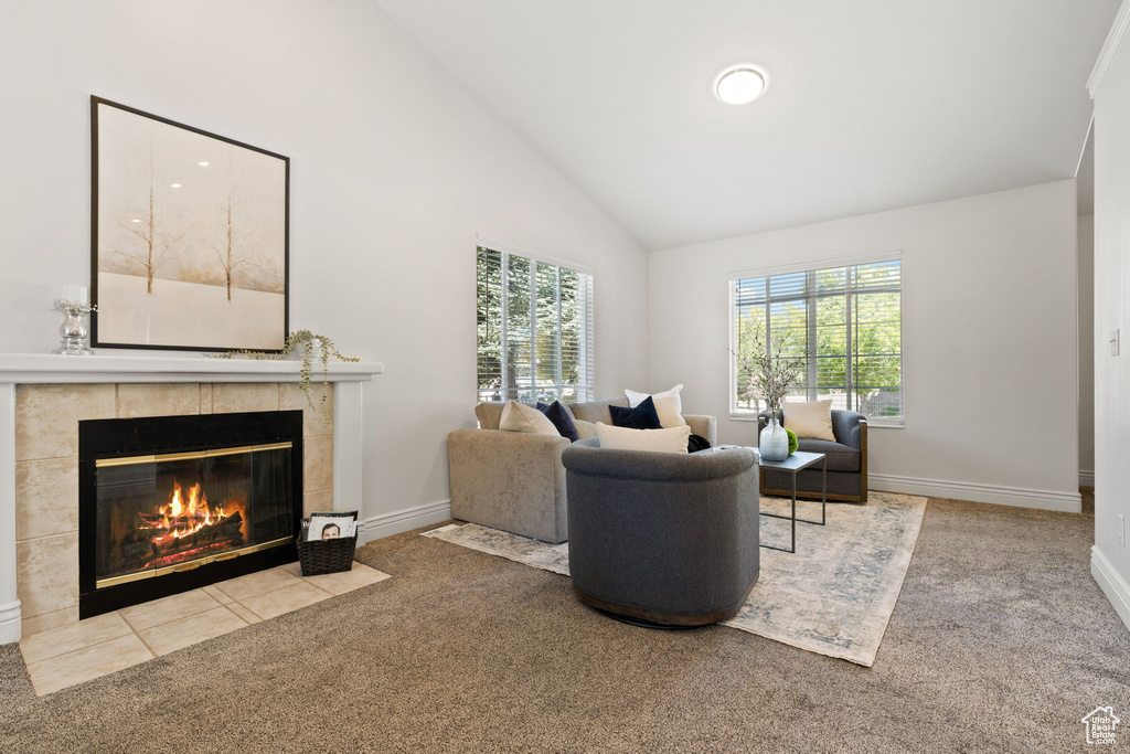 Living room featuring a fireplace, lofted ceiling, and light colored carpet