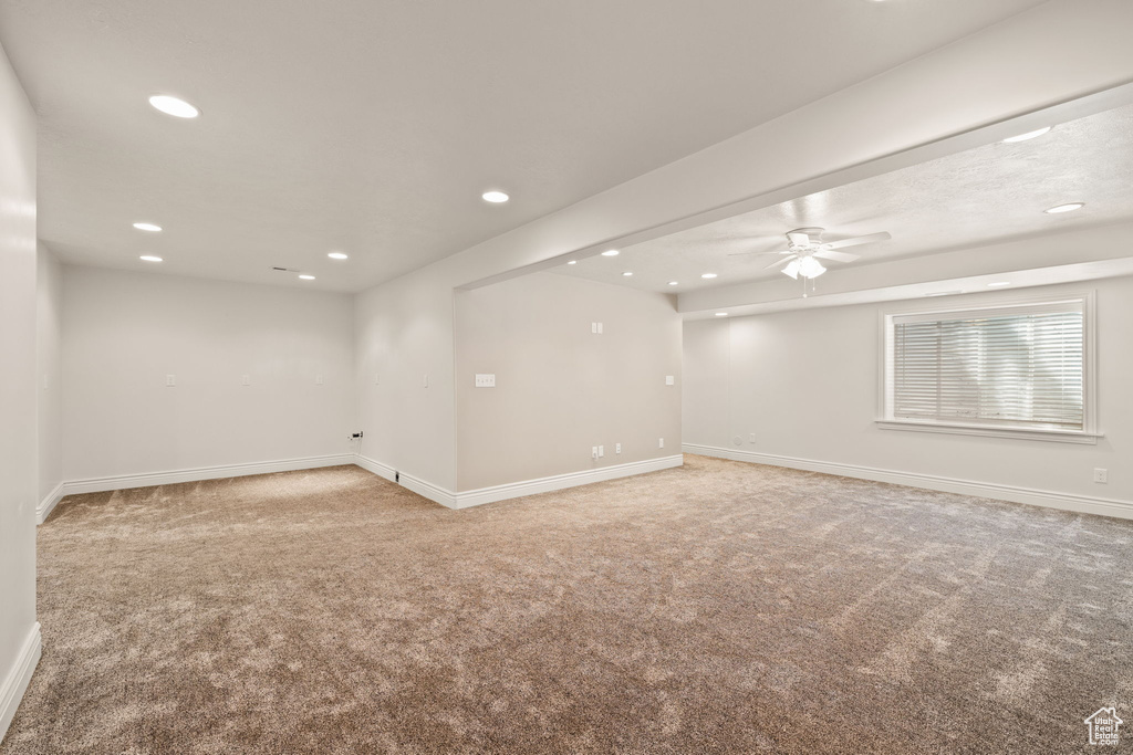 Empty room with light colored carpet and ceiling fan