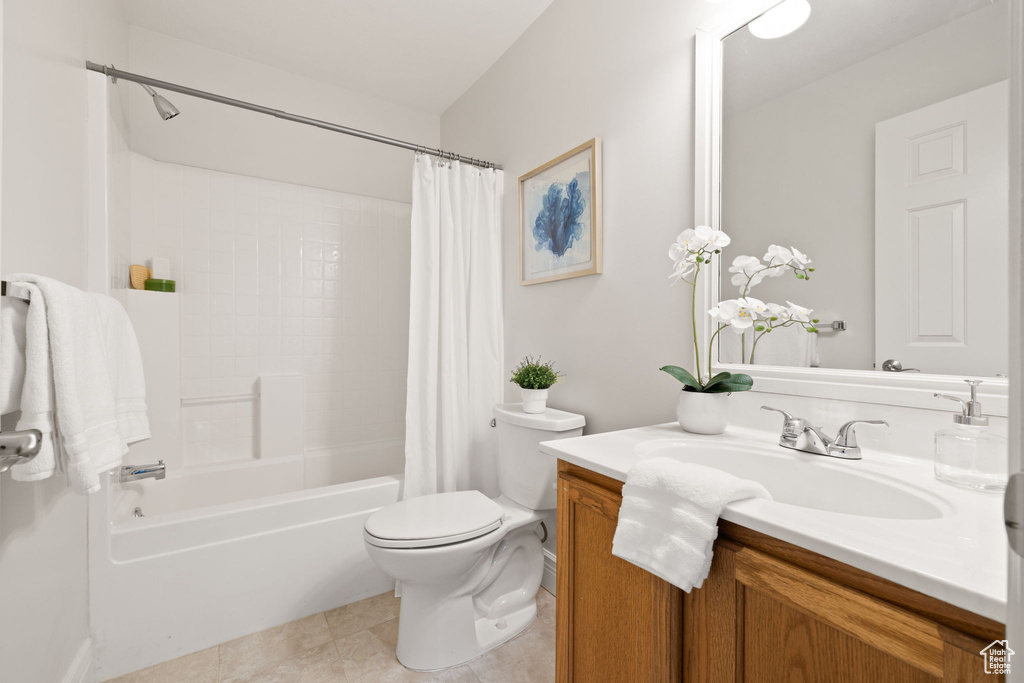 Full bathroom featuring tile patterned flooring, vanity, toilet, and shower / tub combo with curtain