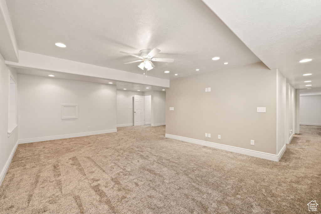 Carpeted spare room with a textured ceiling and ceiling fan