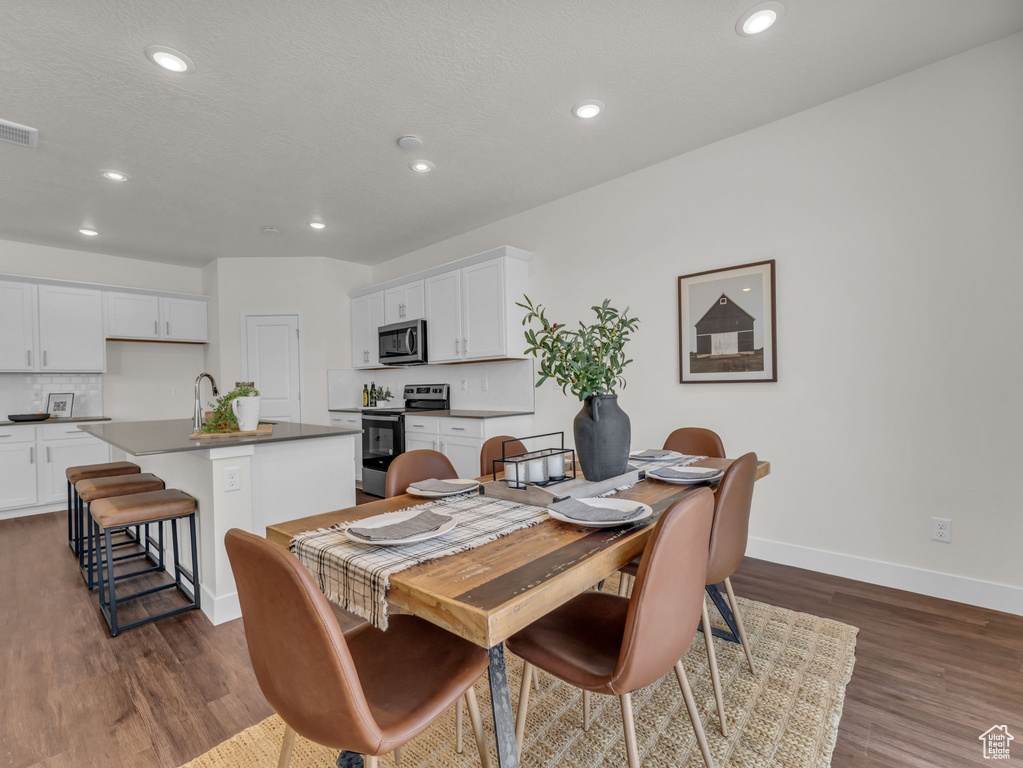 Dining area featuring baseboards, dark wood finished floors, and recessed lighting