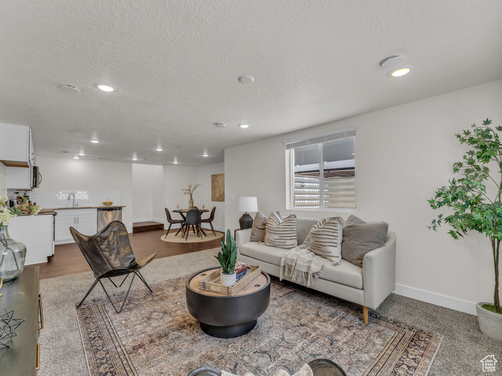 Living area with recessed lighting, baseboards, and a textured ceiling