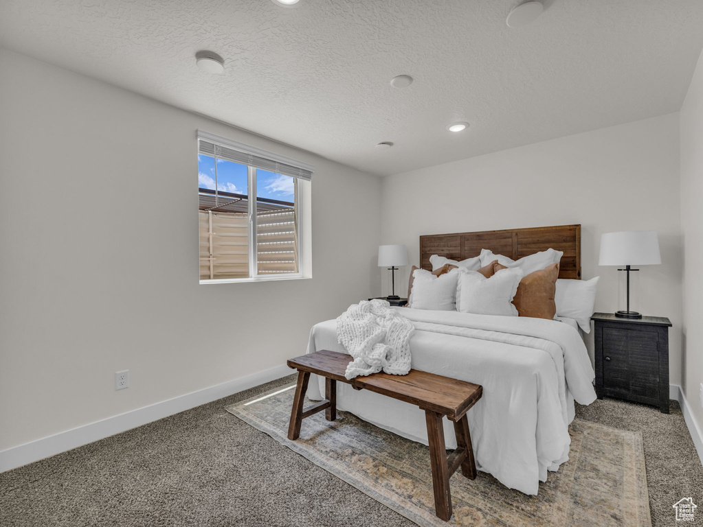 Carpeted bedroom with baseboards, recessed lighting, and a textured ceiling