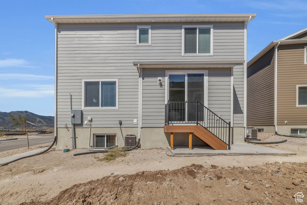Rear view of house featuring a mountain view and cooling unit