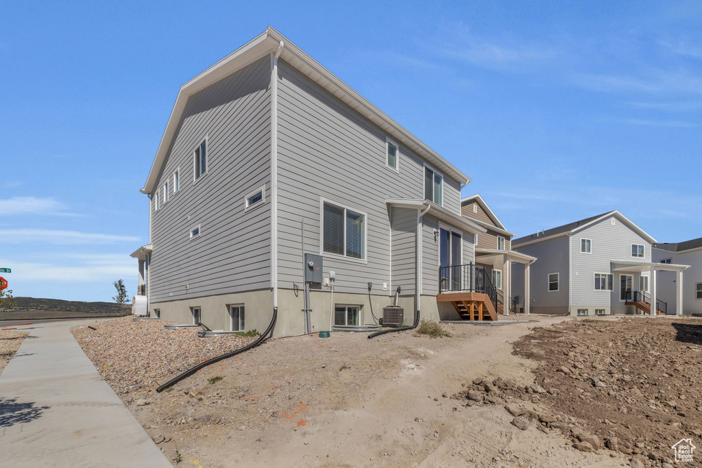 Rear view of property featuring cooling unit