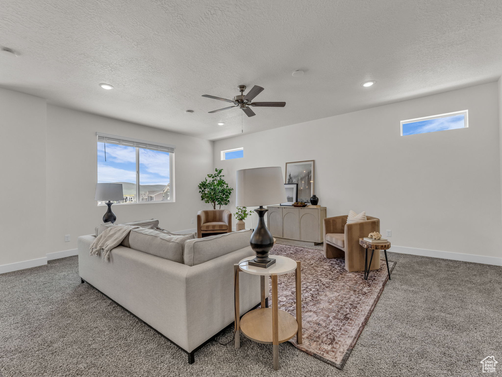 Carpeted living room with recessed lighting, a textured ceiling, ceiling fan, and baseboards
