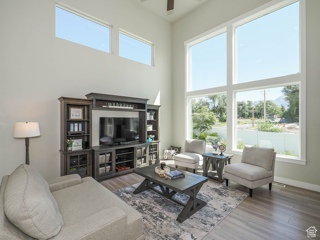 Living room with dark hardwood / wood-style flooring and a towering ceiling