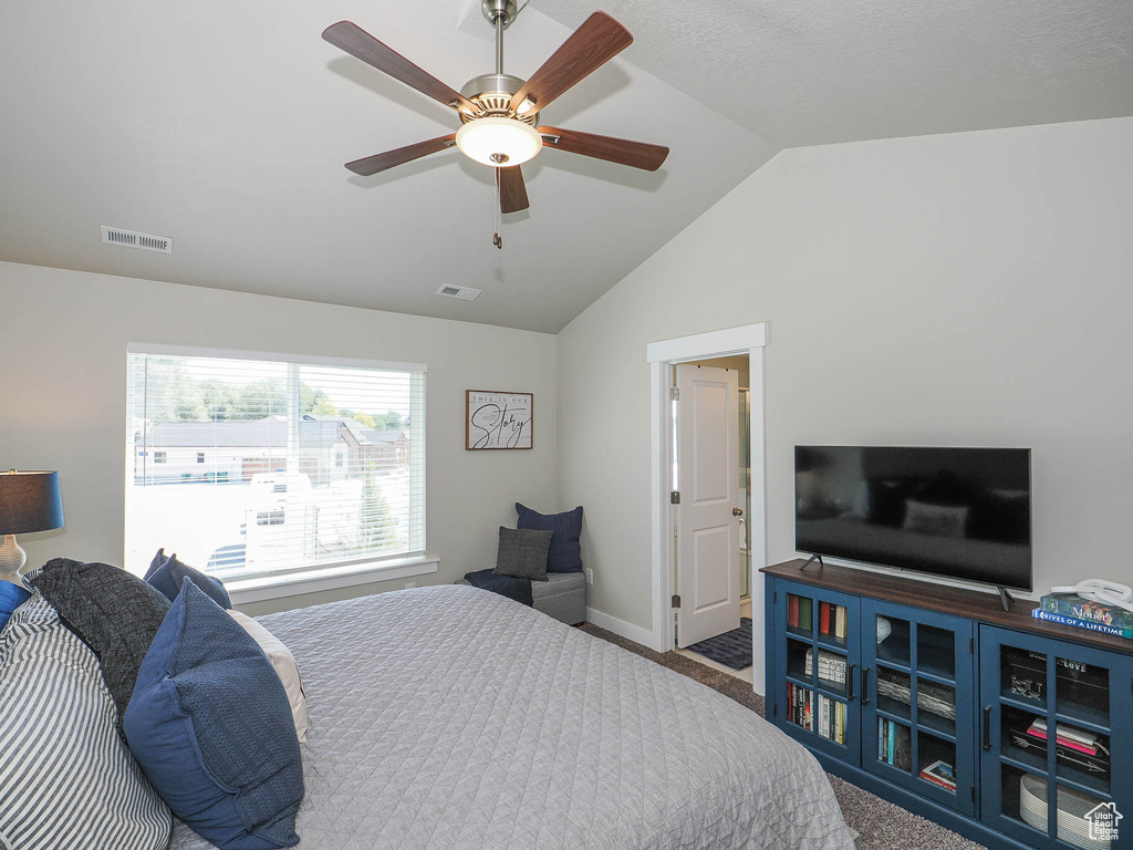 Bedroom featuring vaulted ceiling, ceiling fan, and carpet