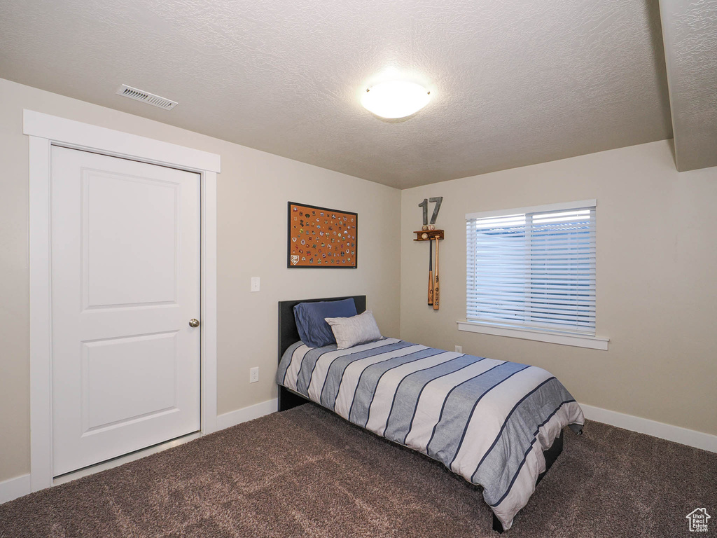 Bedroom with carpet flooring and a textured ceiling