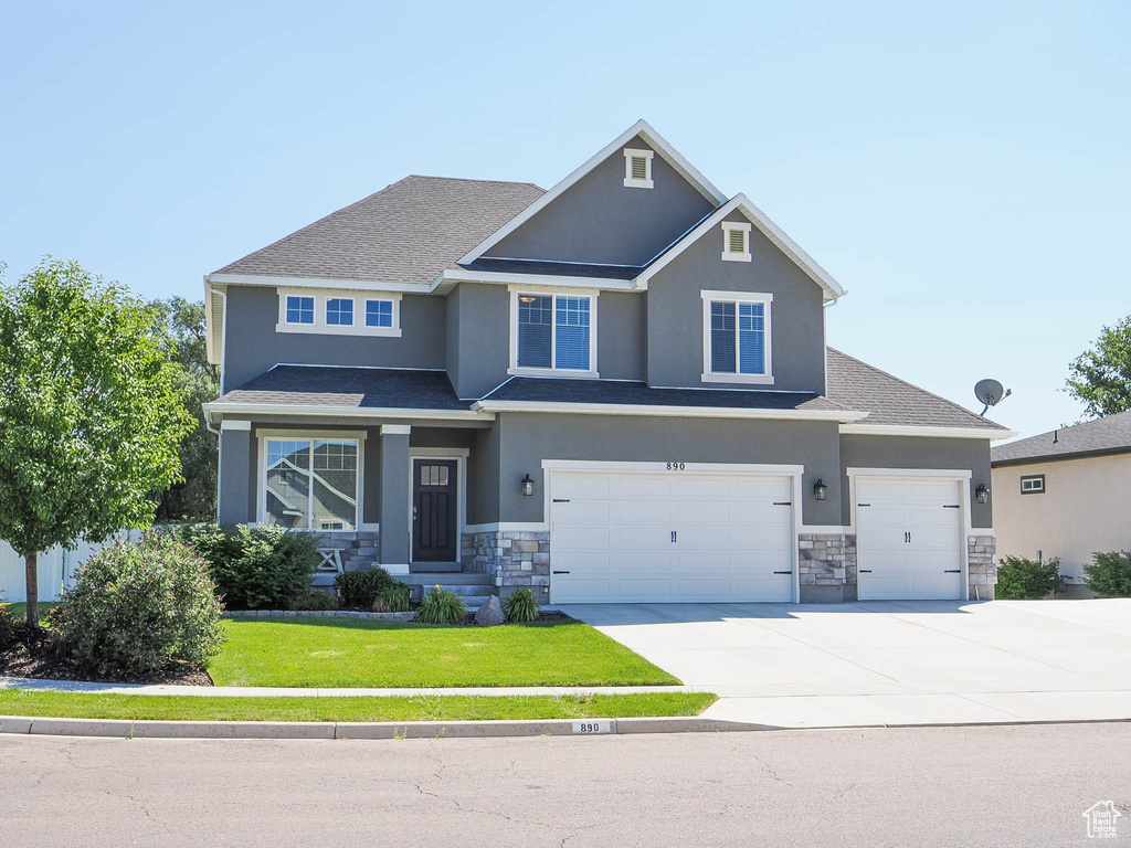 View of front of house featuring a garage and a front lawn