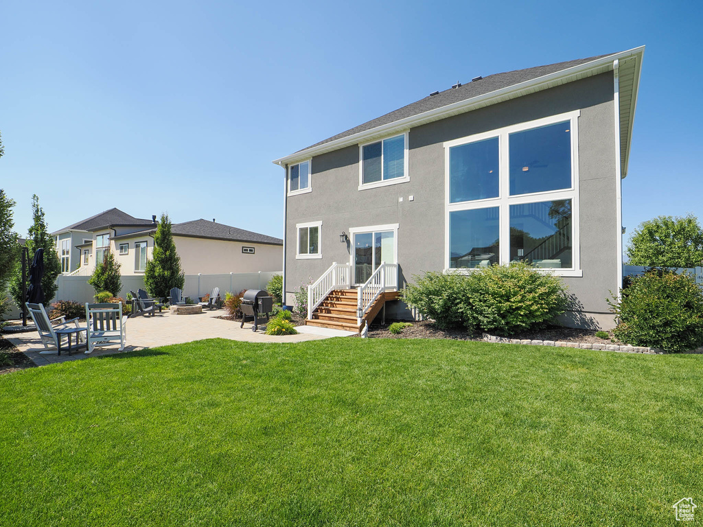 Back of property featuring a lawn and a patio area