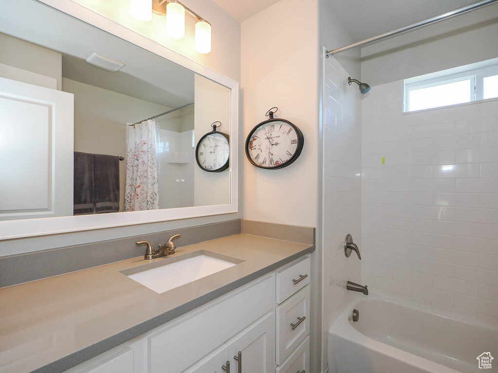 Bathroom with shower / tub combo with curtain and vanity