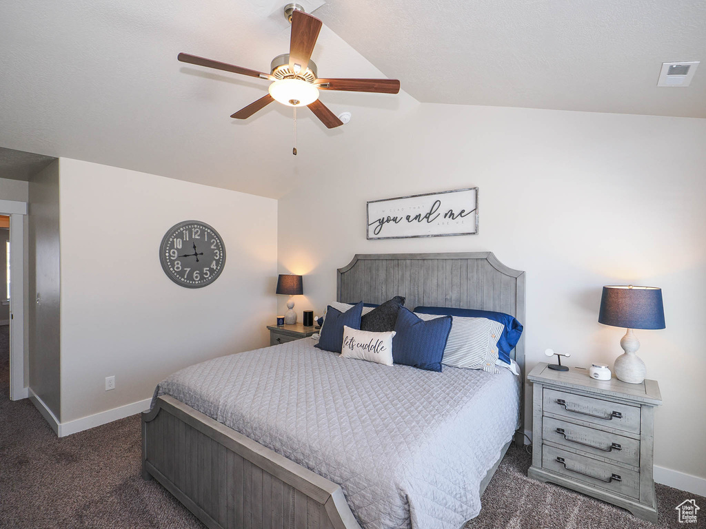 Carpeted bedroom with ceiling fan and vaulted ceiling