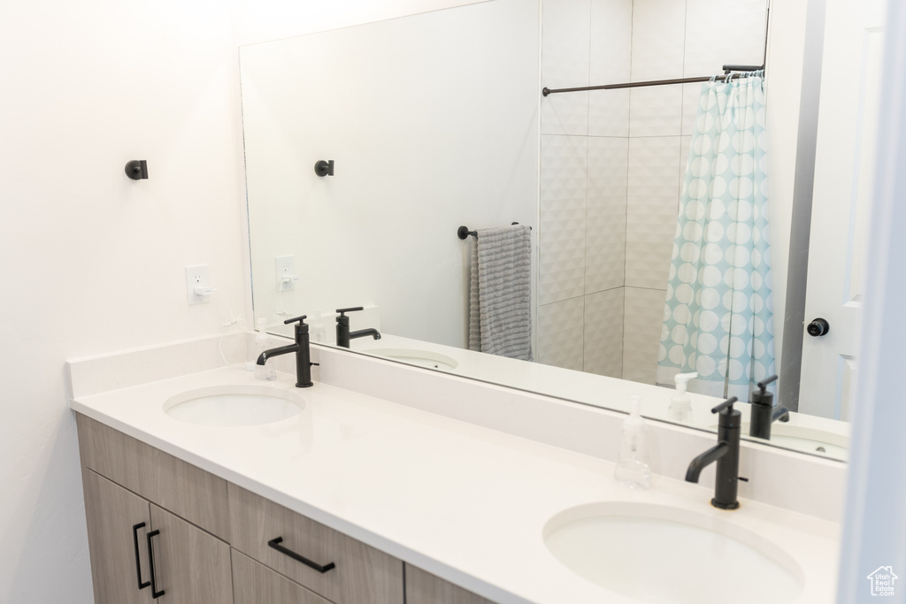 Bathroom featuring a shower with curtain and vanity