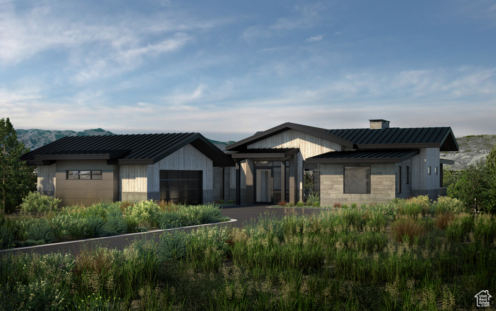 View of front of home featuring a standing seam roof, a chimney, stone siding, and metal roof