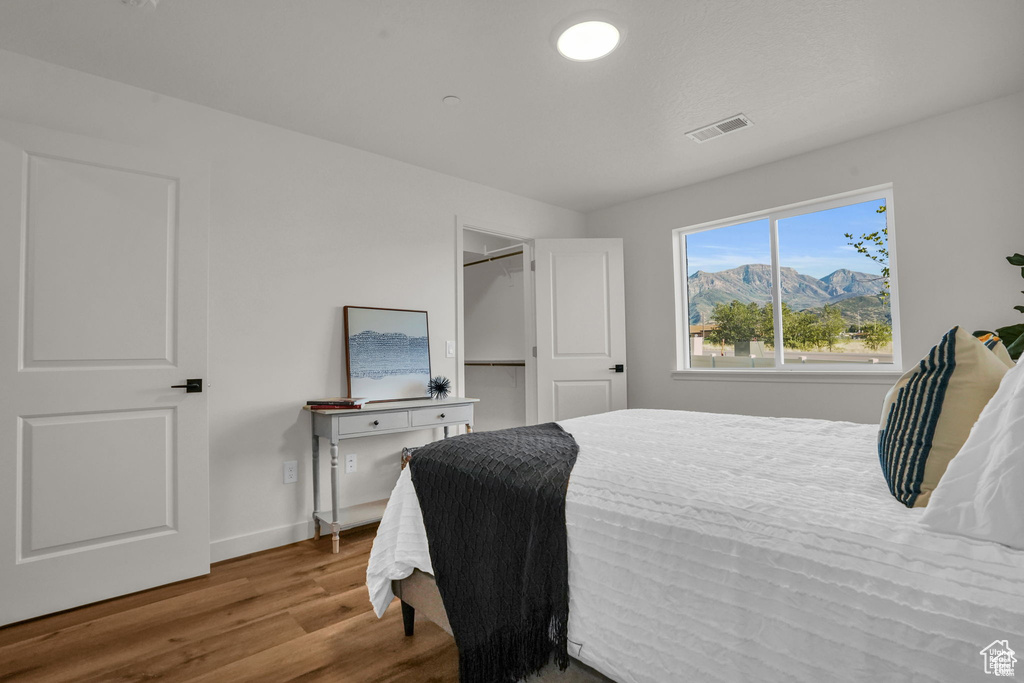 Bedroom with light hardwood / wood-style flooring and a mountain view