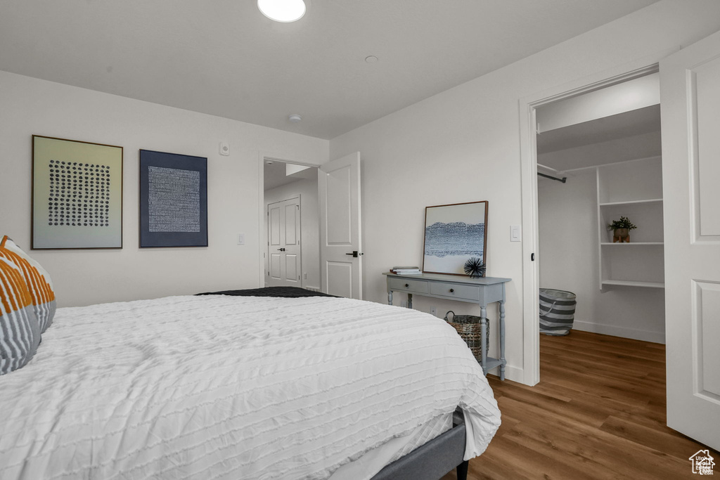 Bedroom featuring hardwood / wood-style flooring and a walk in closet