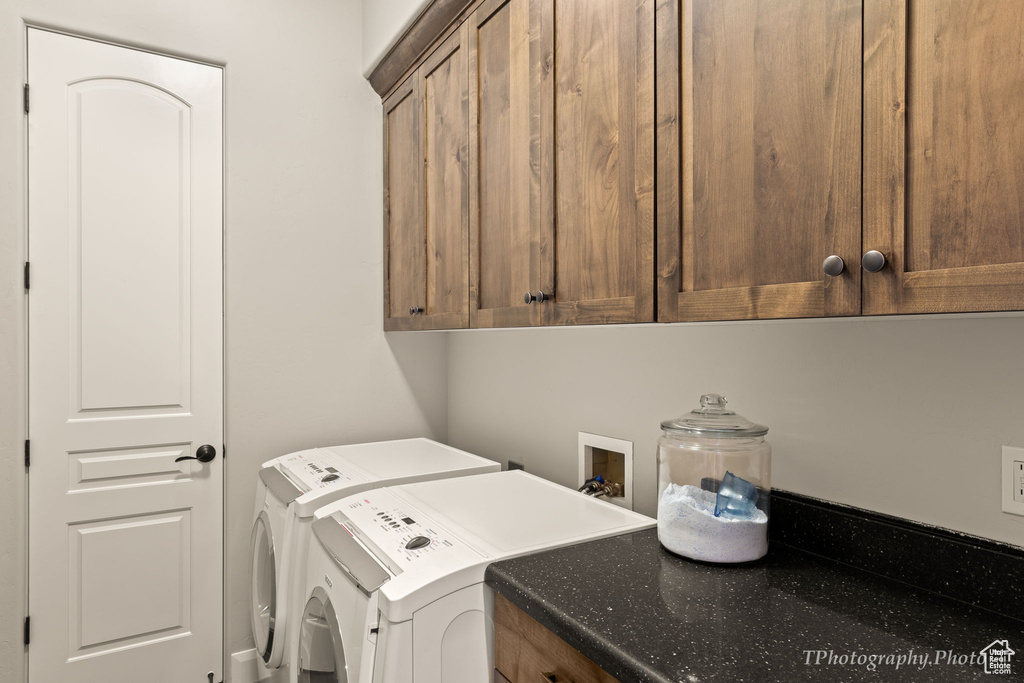 Laundry area with washer and clothes dryer and cabinets