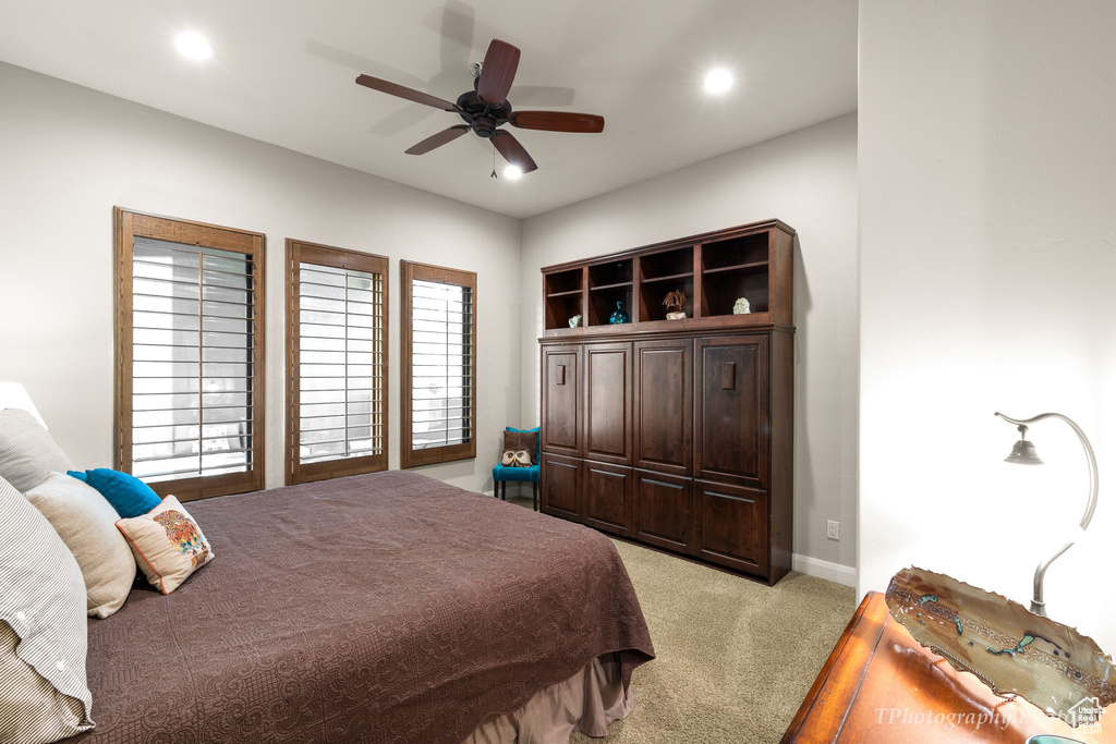 Bedroom with ceiling fan and light colored carpet