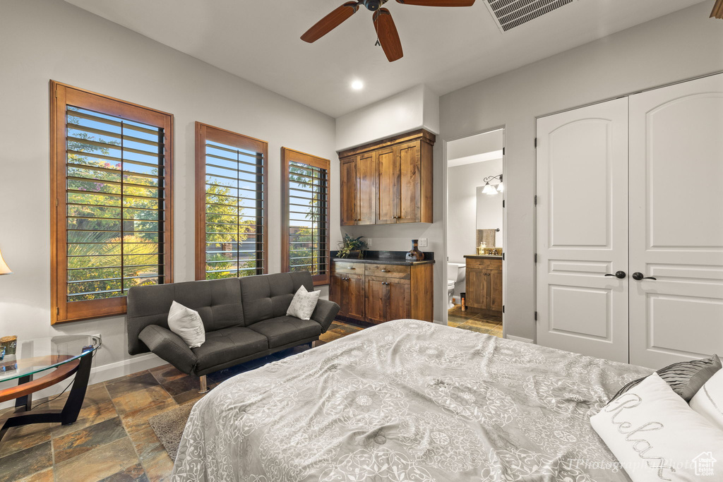 Bedroom featuring a closet, ceiling fan, connected bathroom, and dark tile patterned floors