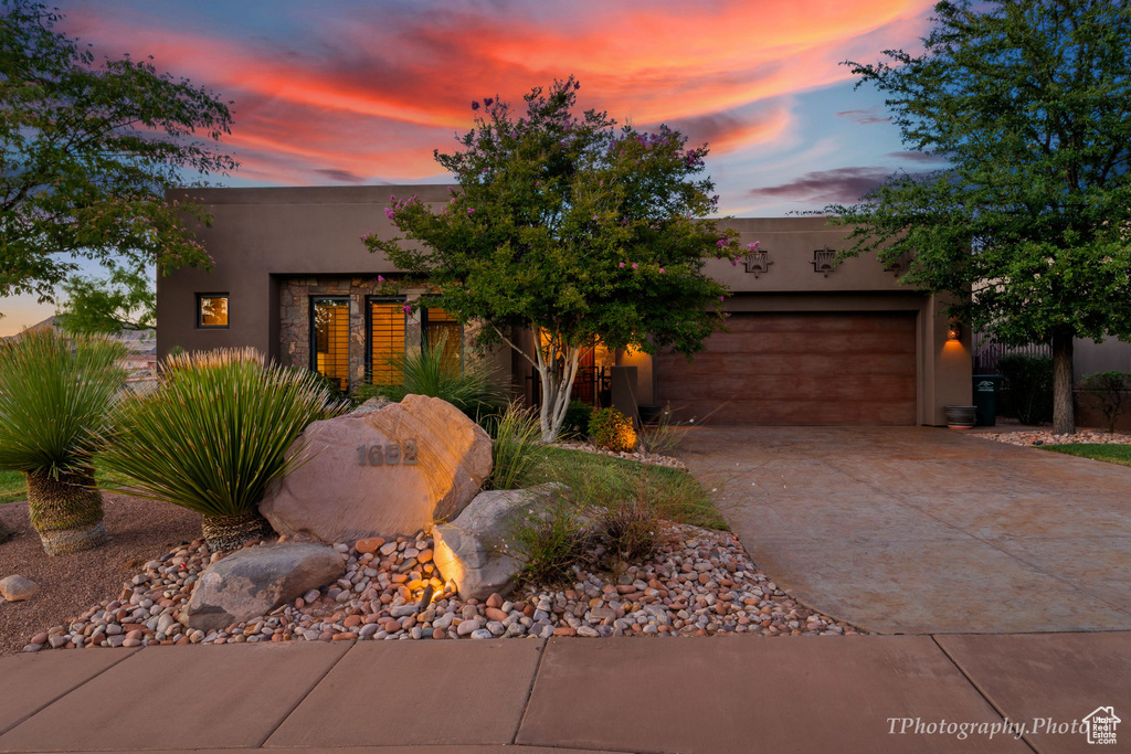 Pueblo-style home featuring a garage