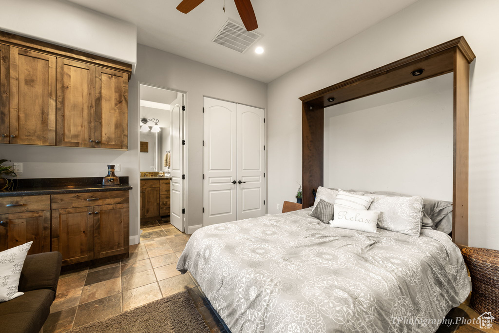 Tiled bedroom featuring ceiling fan, a closet, and ensuite bathroom