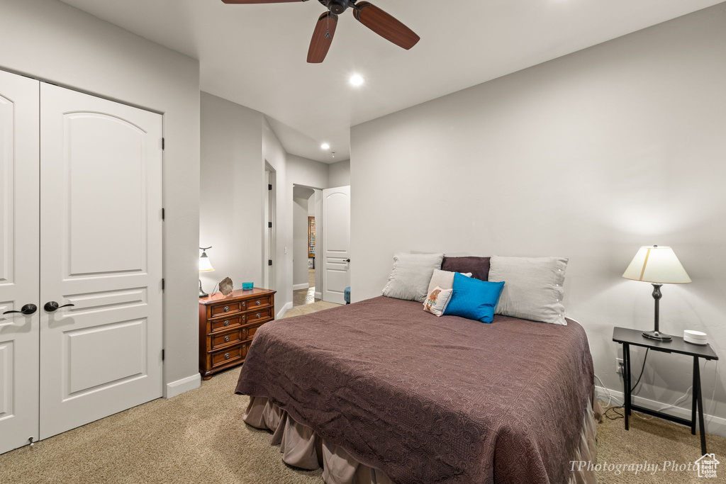 Bedroom featuring a closet, ceiling fan, and light carpet