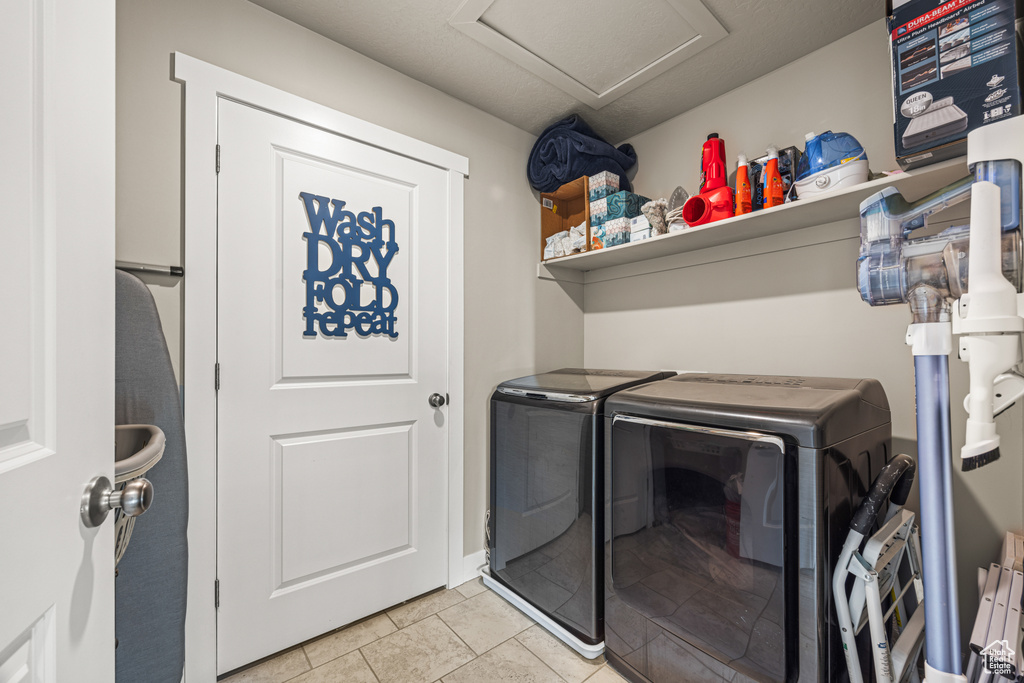 Laundry area with light tile patterned floors and washer and clothes dryer