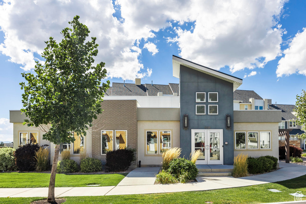 View of front of property with a front lawn and french doors