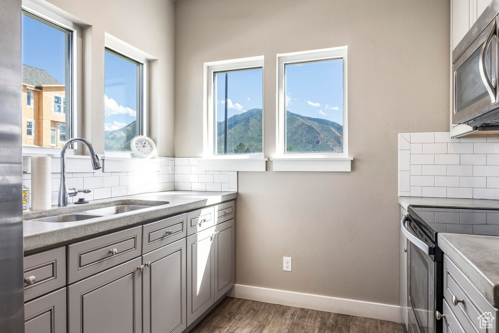 Kitchen featuring appliances with stainless steel finishes, a mountain view, sink, dark hardwood / wood-style floors, and tasteful backsplash