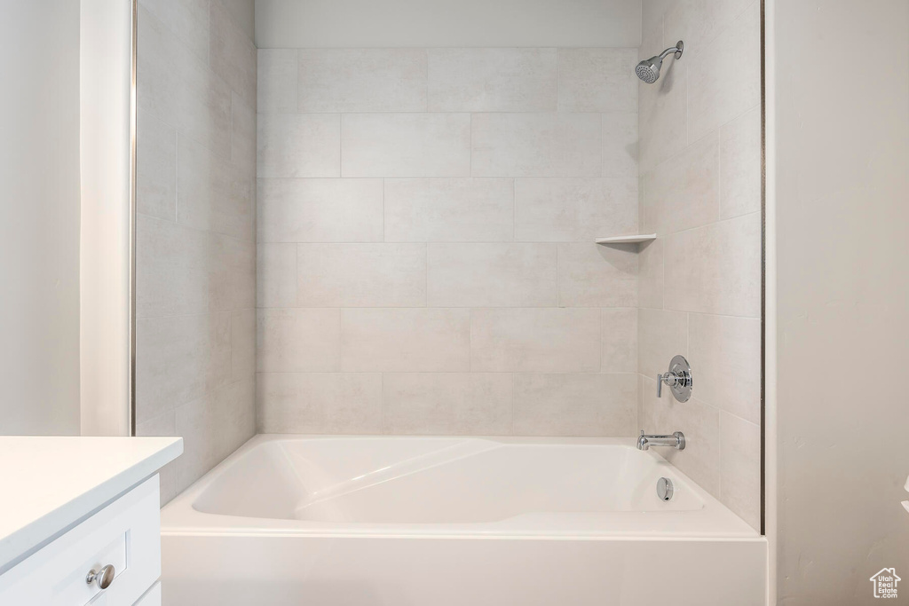 Bathroom featuring tiled shower / bath and vanity