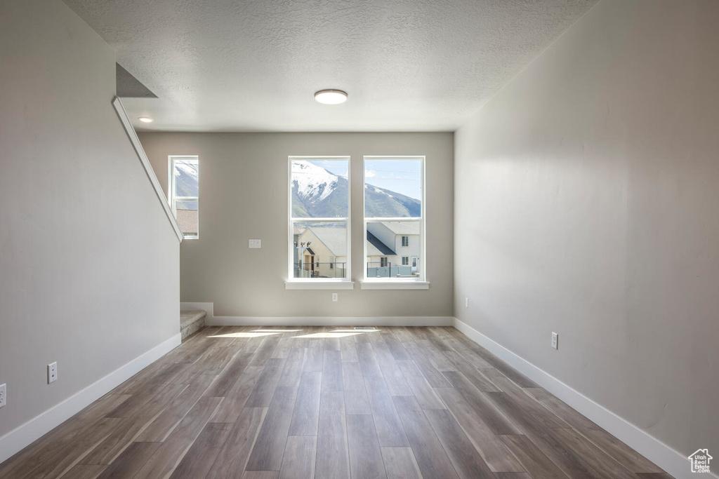 Empty room featuring hardwood / wood-style floors and a textured ceiling