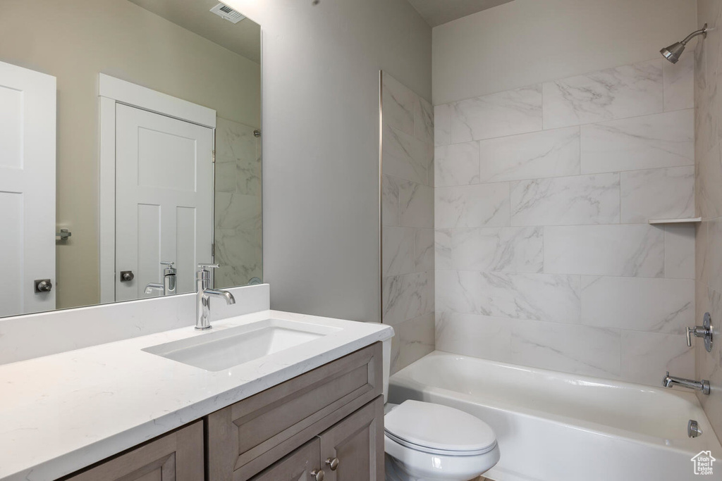 Full bathroom with vanity, toilet, and tiled shower / bath