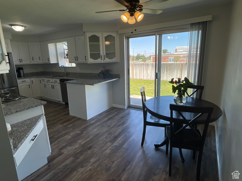 Kitchen featuring white cabinetry, sink, ceiling fan, dark hardwood / wood-style floors, and stone countertops