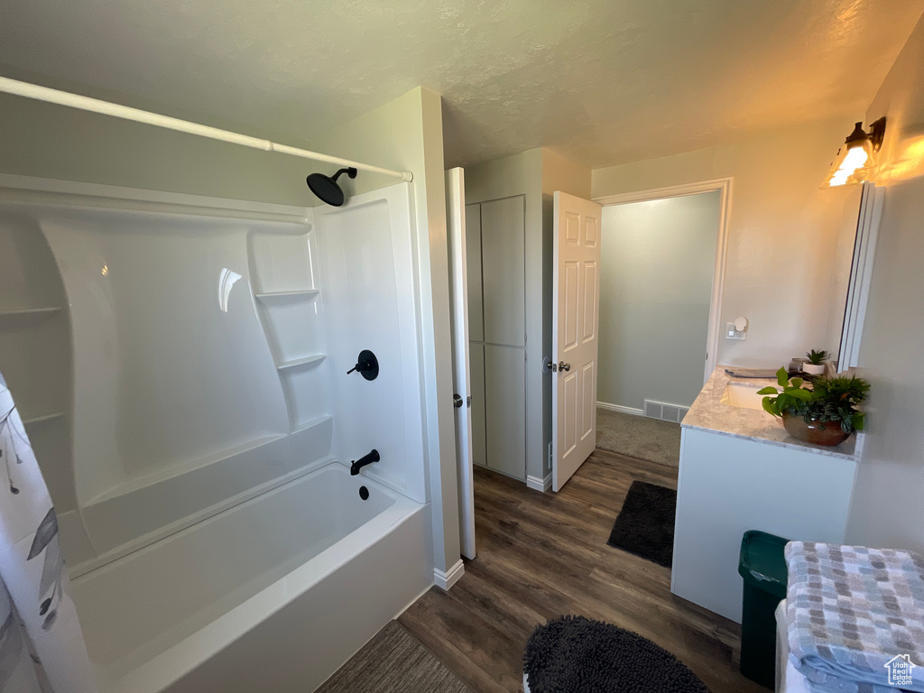 Bathroom featuring hardwood / wood-style flooring, shower / bathing tub combination, and vanity