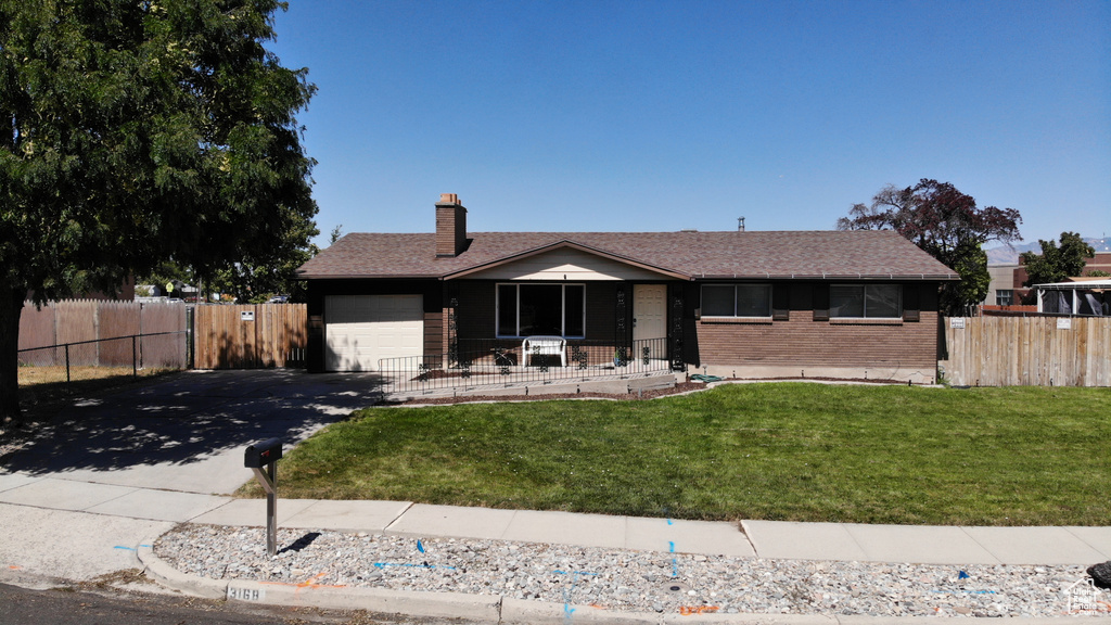 Single story home featuring a garage and a front lawn