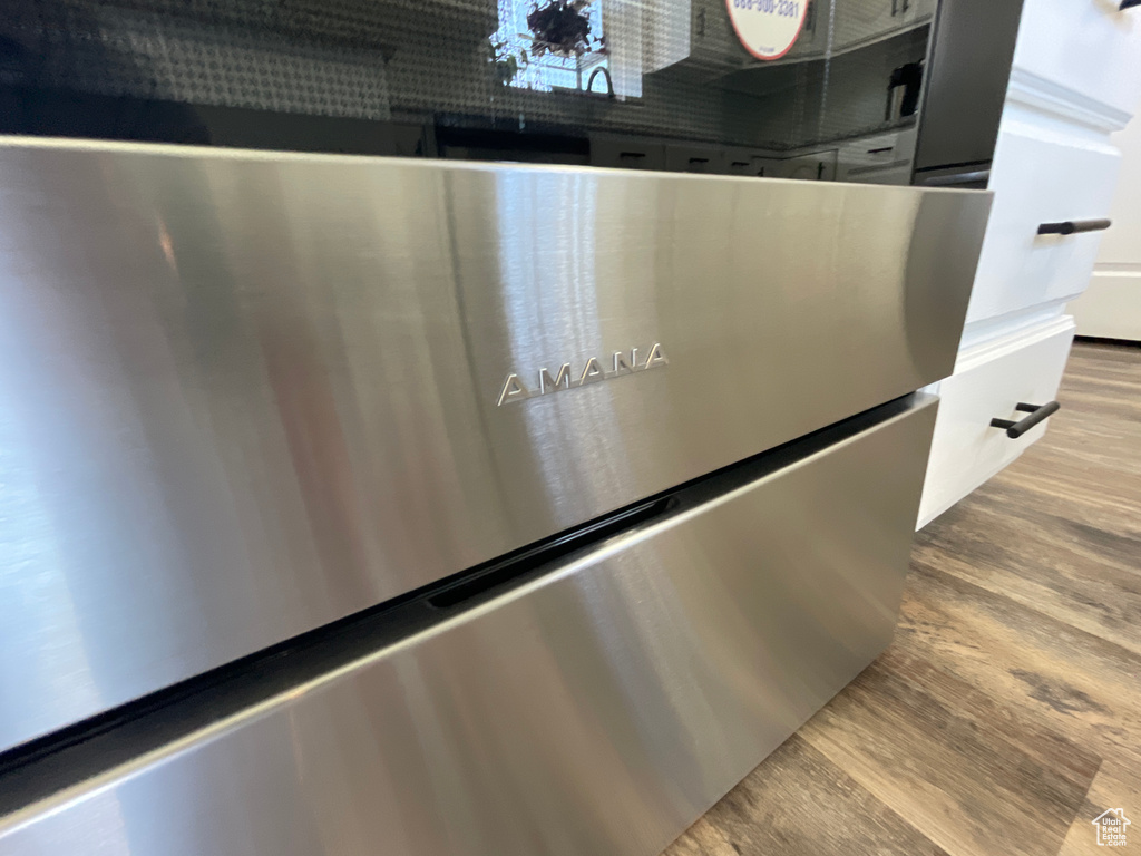 Details with stainless steel dishwasher and wood-type flooring