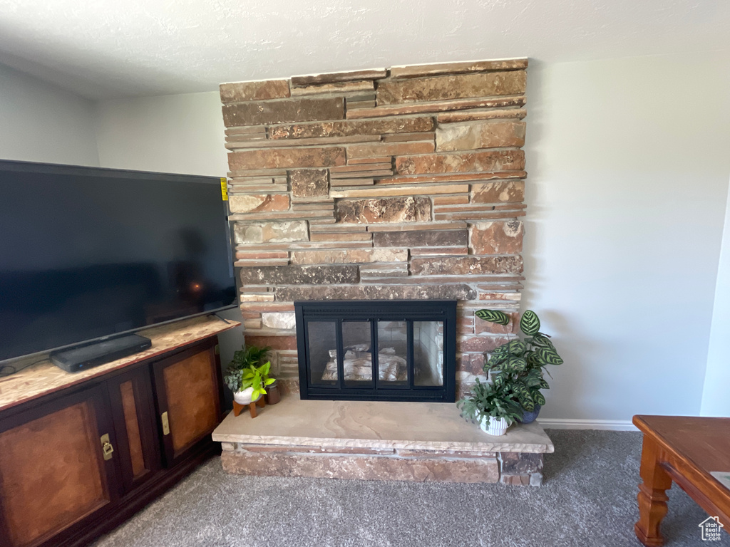 Carpeted living room with a fireplace and a textured ceiling