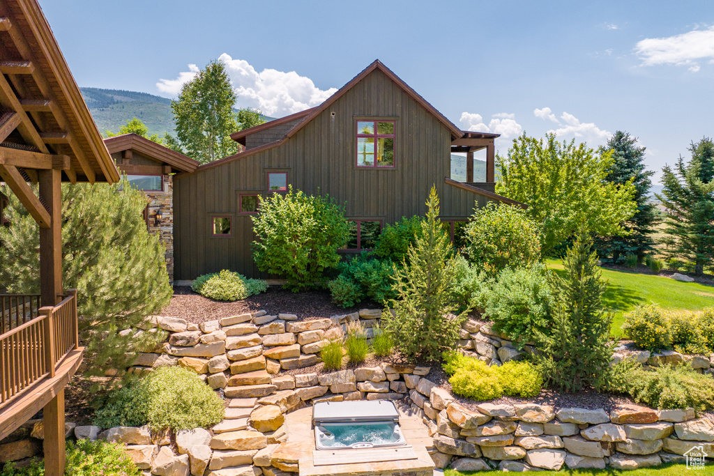 Exterior space featuring a mountain view and an outdoor hot tub