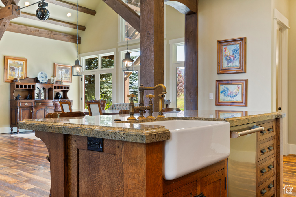 Kitchen featuring sink, beamed ceiling, high vaulted ceiling, and light hardwood / wood-style floors