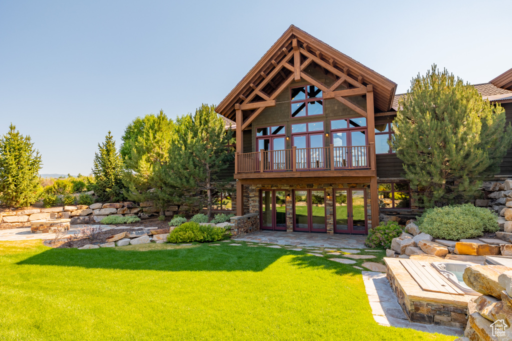 Rear view of property featuring a patio, a lawn, and a wooden deck