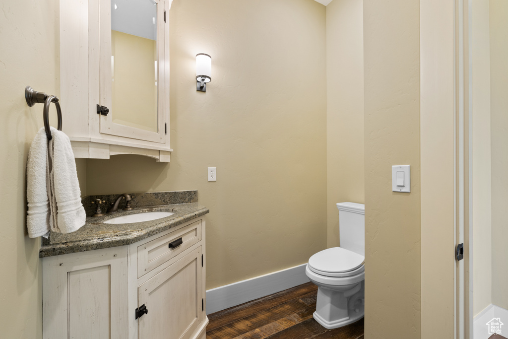 Bathroom featuring vanity, toilet, and hardwood / wood-style flooring