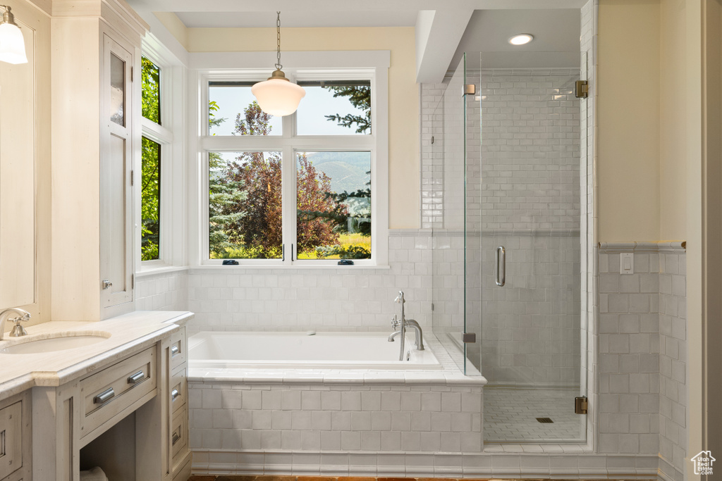 Bathroom featuring plus walk in shower and vanity