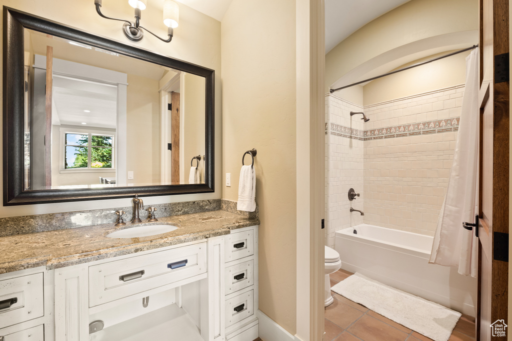 Full bathroom featuring vanity, toilet, tile patterned floors, and tiled shower / bath