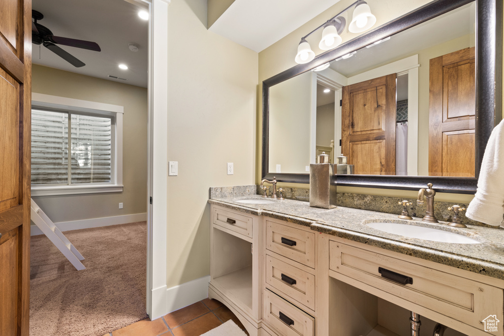 Bathroom featuring vanity, ceiling fan, and tile patterned flooring