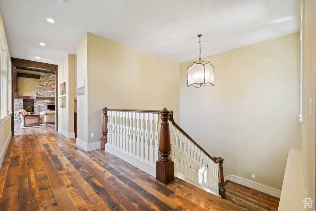 Hallway featuring dark wood-type flooring and a chandelier