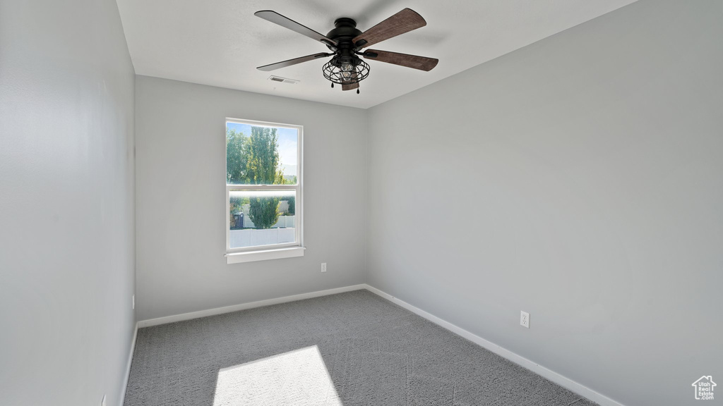 Empty room with ceiling fan and carpet floors