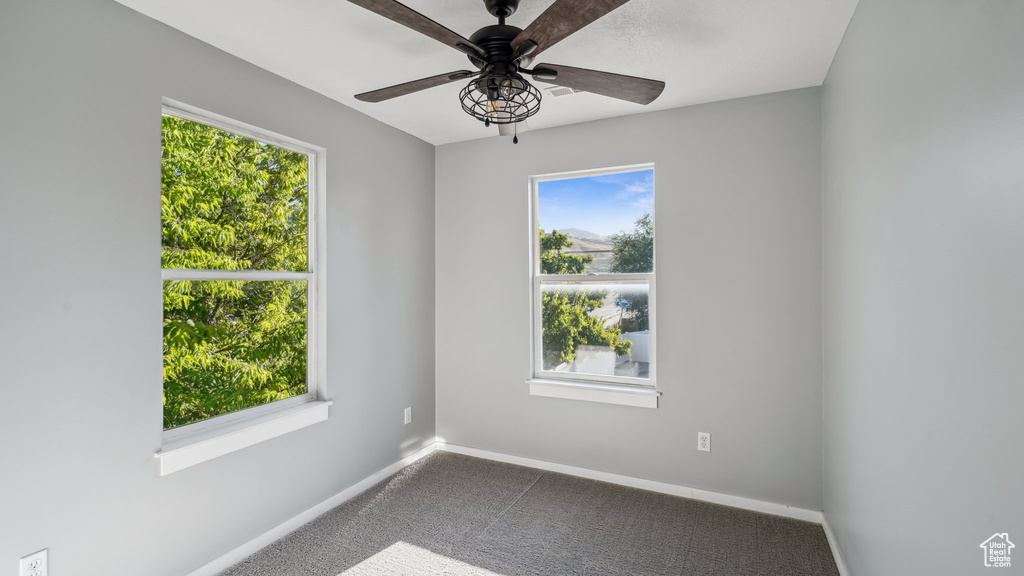 Carpeted spare room featuring ceiling fan