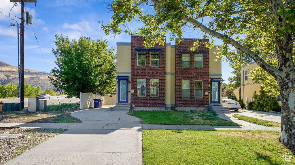 View of front of property featuring a mountain view and a front lawn